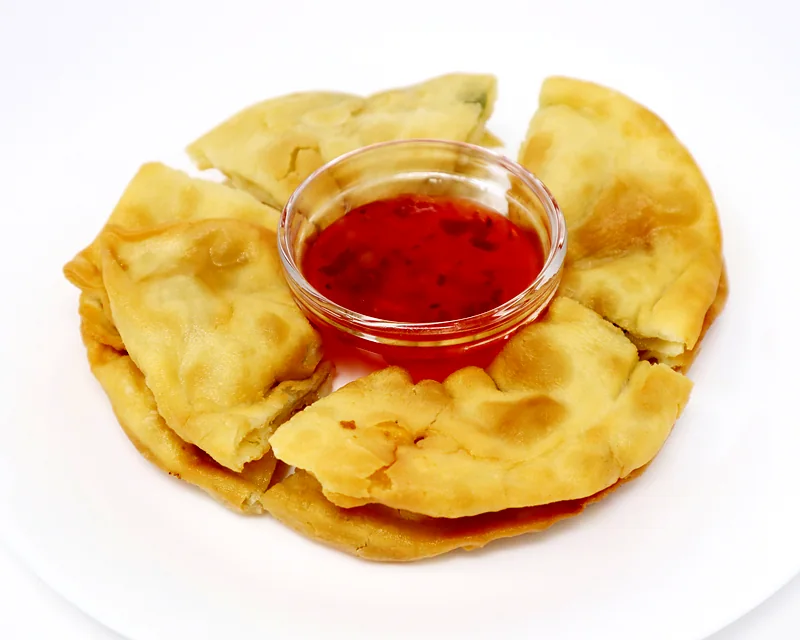 Green onion cake cut into wedges with sweet chili dipping sauce